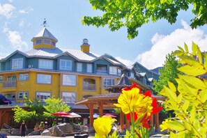 A multi-story building with balconies, a covered patio area, and a clear sky. - Bear Lodge One Bedroom by MVA (Whistler)