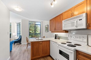 A modern kitchen with wooden cabinets, a white stove, and a microwave.
