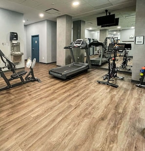 Ein Fitnessstudio mit Laufbändern, Crosstrainern und Gewichtswesen.