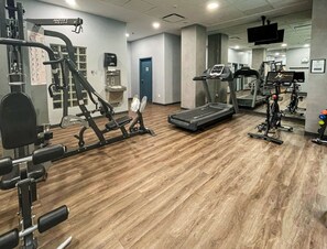 A gym with exercise equipment, a water dispenser, and a treadmill. - Alpenglow Lodge Large Studio with Dedicated Work Space by MVA (Whistler)
