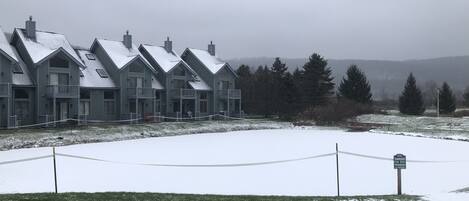 A row of multi-story buildings with a snow-covered lawn and a 'No Entry' sign.