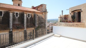 Ein Balkon mit Steinbalustrade mit Blick auf eine Stadtlandschaft.