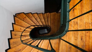 A wooden spiral staircase with metal handrails.