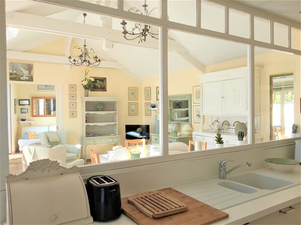 A kitchen with a toaster, a wooden cutting board, and a sink.