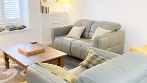 A living room with a sofa, a coffee table, and a bookshelf.