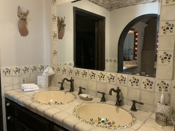 Un bany amb dues dutxes, un mirall i un àngel decoratiu.