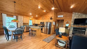L’intérieur d’une cabane en bois comprend une cuisine, un coin repas et un salon.