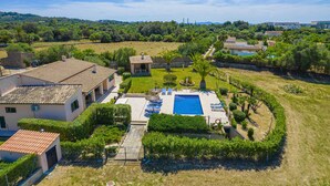A residential property with a swimming pool, a covered patio, and a view of a green landscape. - Villa Ca na Quarta (Alcúdia)