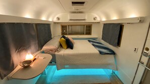 A compact, well-lit room with a bed, bedside table, and a window. - The Austin LoveStream! New Hot Tub, Full Bathroom, Deck & Grill! (Austin)