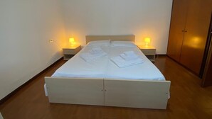 A single bed with a wooden frame, two bedside tables with lamps, and a wardrobe. - RES Falena apartment within walking distance of the hospital and the city center (Padova)
