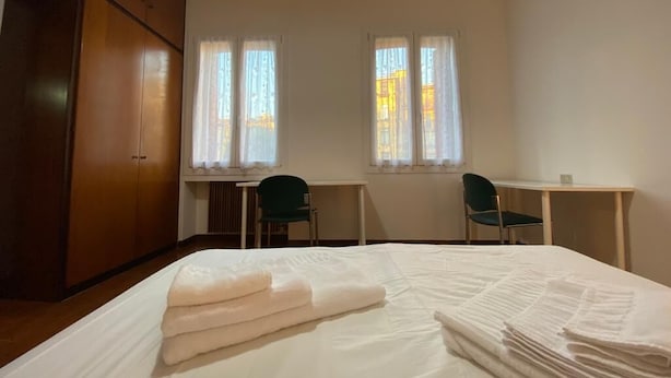 A hotel room with a bed, two chairs, a desk, and a wardrobe. - RES Falena apartment within walking distance of the hospital and the city center (Padova)