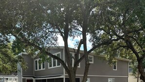 A two-story house with a covered front porch and a garage. - Lower Level, Apartment Style Beach House! (Surfside Beach)
