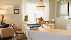 A modern kitchen with a central island, a dining area with chairs, and a pendant light. - Luxury villa in beautiful Brunswick Plantation. Sunset Beach/Ocean Isle/Calabash (Calabash)