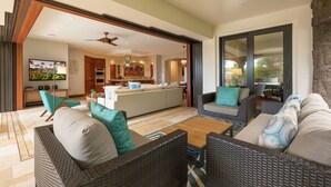 An open-plan living area with a kitchen, dining space, and a large sliding glass door leading to an outdoor patio.
