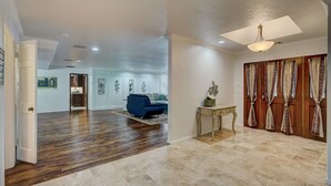 Un salon spacieux doté d’un plancher en bois, d’un canapé bleu, d’une petite table et d’un ventilateur de plafond.