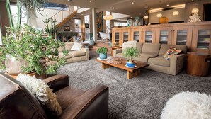 Un amplio salón con un conjunto de sofás, una mesa de centro y una planta grande en maceta.