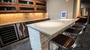 Una cocina moderna con encimera de granito, electrodomésticos de acero inoxidable y salpicadero de piedra.