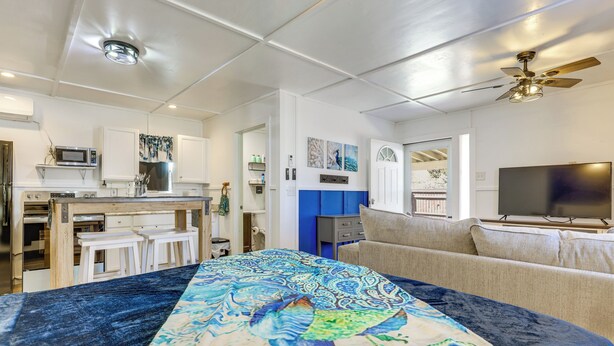 A modern hotel room with a large bed, a TV, a ceiling fan, a kitchenette, and a bathroom. - Pet-Friendly Canyon Lake Studio: Fish, Boat, Relax (Canyon Lake)