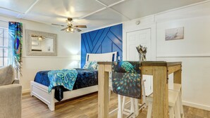 A bedroom with a bed, a chair, a table, a ceiling fan, a mirror, and a door. - Pet-Friendly Canyon Lake Studio: Fish, Boat, Relax (Canyon Lake)