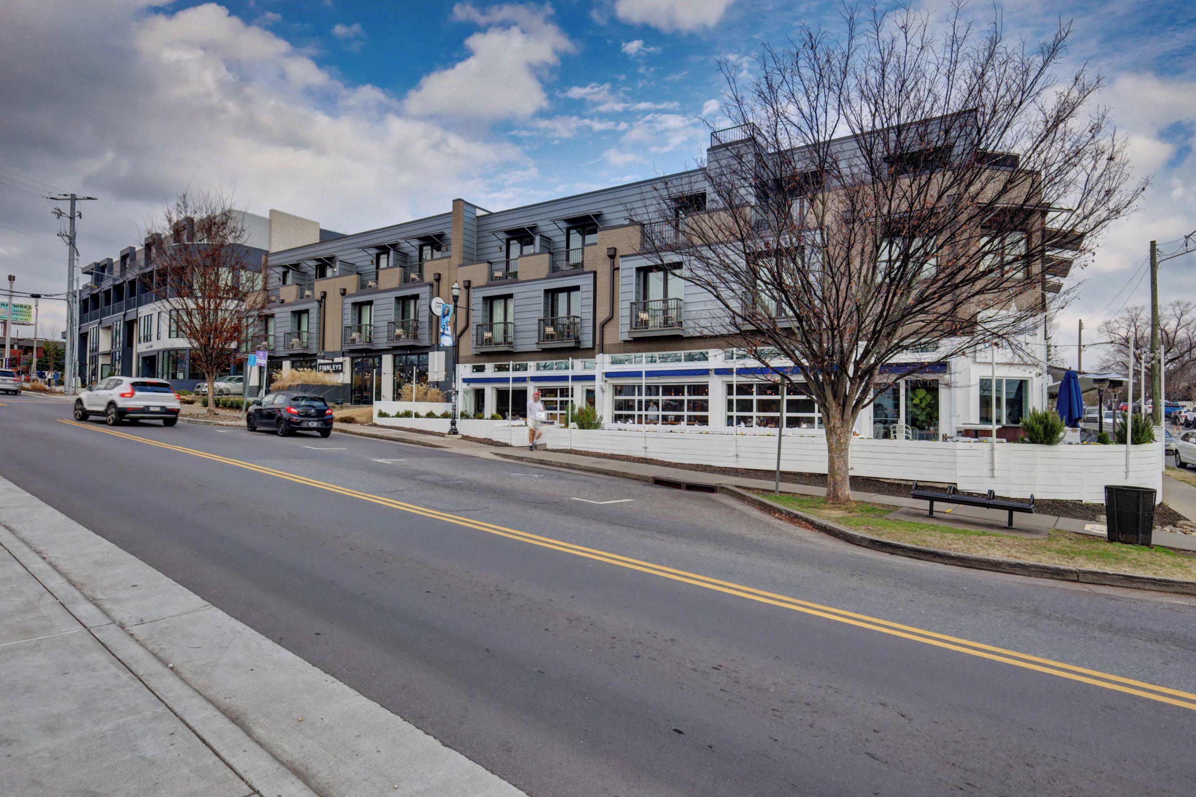 A multi-story building with a modern architectural style, featuring balconies and large windows.