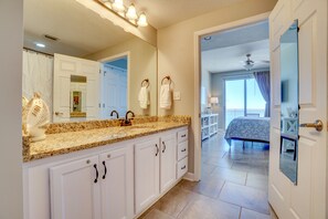 Un baño con un espejo grande, un lavabo y un mueble de tocador con cajones.