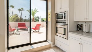 A modern kitchen with white cabinets, a microwave, and an oven. - Ivory I By AvantStay | Modern Home w/ Stunning Views | Close To Old Town (Scottsdale)