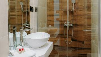 Un bagno moderno con cabina doccia in vetro, lavandino bianco e uno specchio grande.