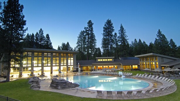 A swimming pool with lounge chairs and a building with large windows. - GM239: Private Hot Tub + Family/Dog Friendly + Central AC (Sisters)