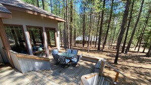 A wooden deck with a glass-enclosed dining area and a built-in bench. - GM239: Private Hot Tub + Family/Dog Friendly + Central AC (Sisters)