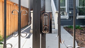 A metal gate with a keypad lock.
