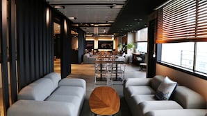 Un interior moderno con una larga mesa de comedor, sofás grises y una mesa de centro de madera.