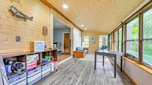 A wooden interior with a reception desk, storage units, and a seating area with a view through large windows. - Lakefront Cabin w/ Fire Pit, Dock, & Boat Rental (Augusta)