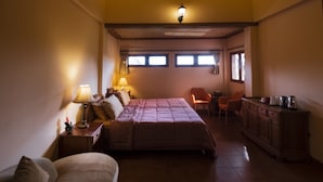 A bedroom with a bed, bedside tables, a chair, a desk, and a cabinet. - Kemangi Apartments and Yoga Space (Ubud)