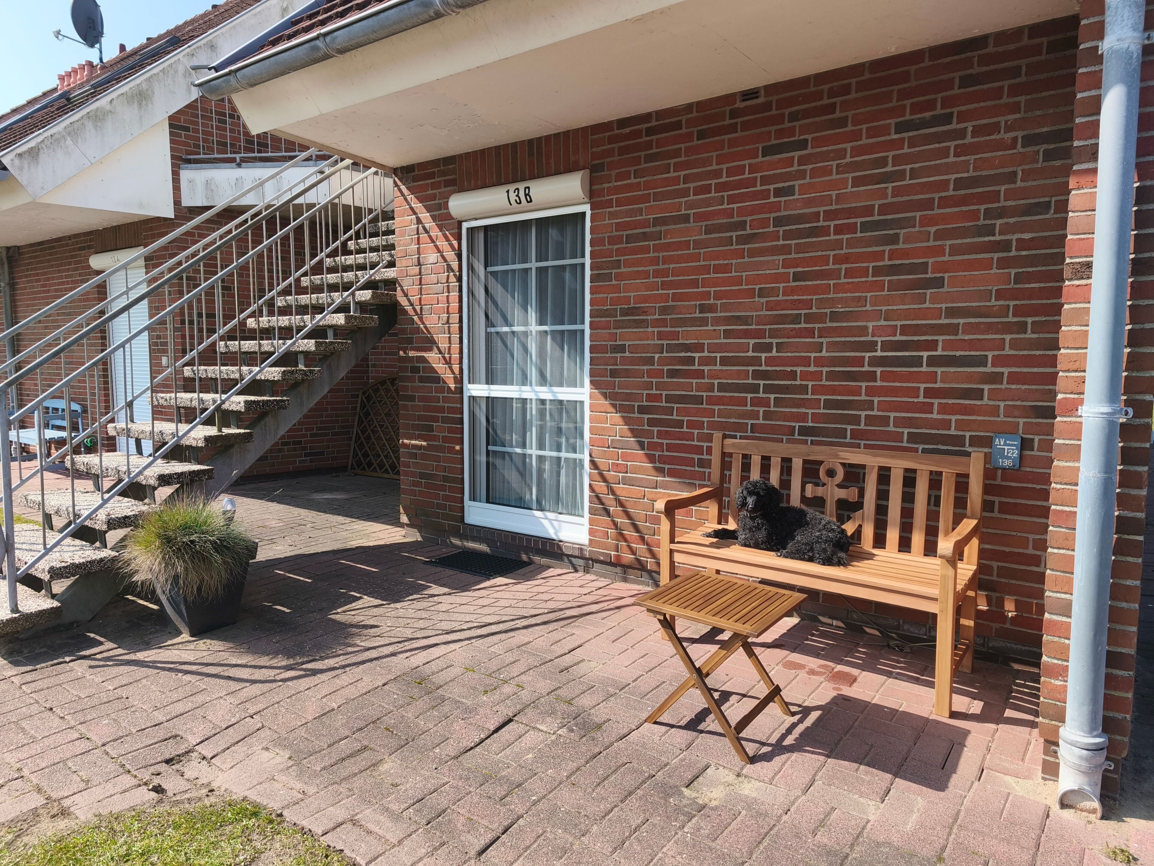 A brick building with a wooden bench and a small table.