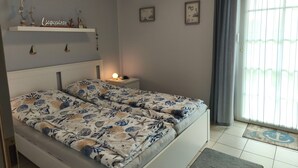 Ett sovrum med en säng, ett sängbord, dekorationer på väggen och en utsikt genom ett fönster.