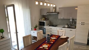 Una cocina moderna con armarios blancos, horno empotrado y estufa a gas.