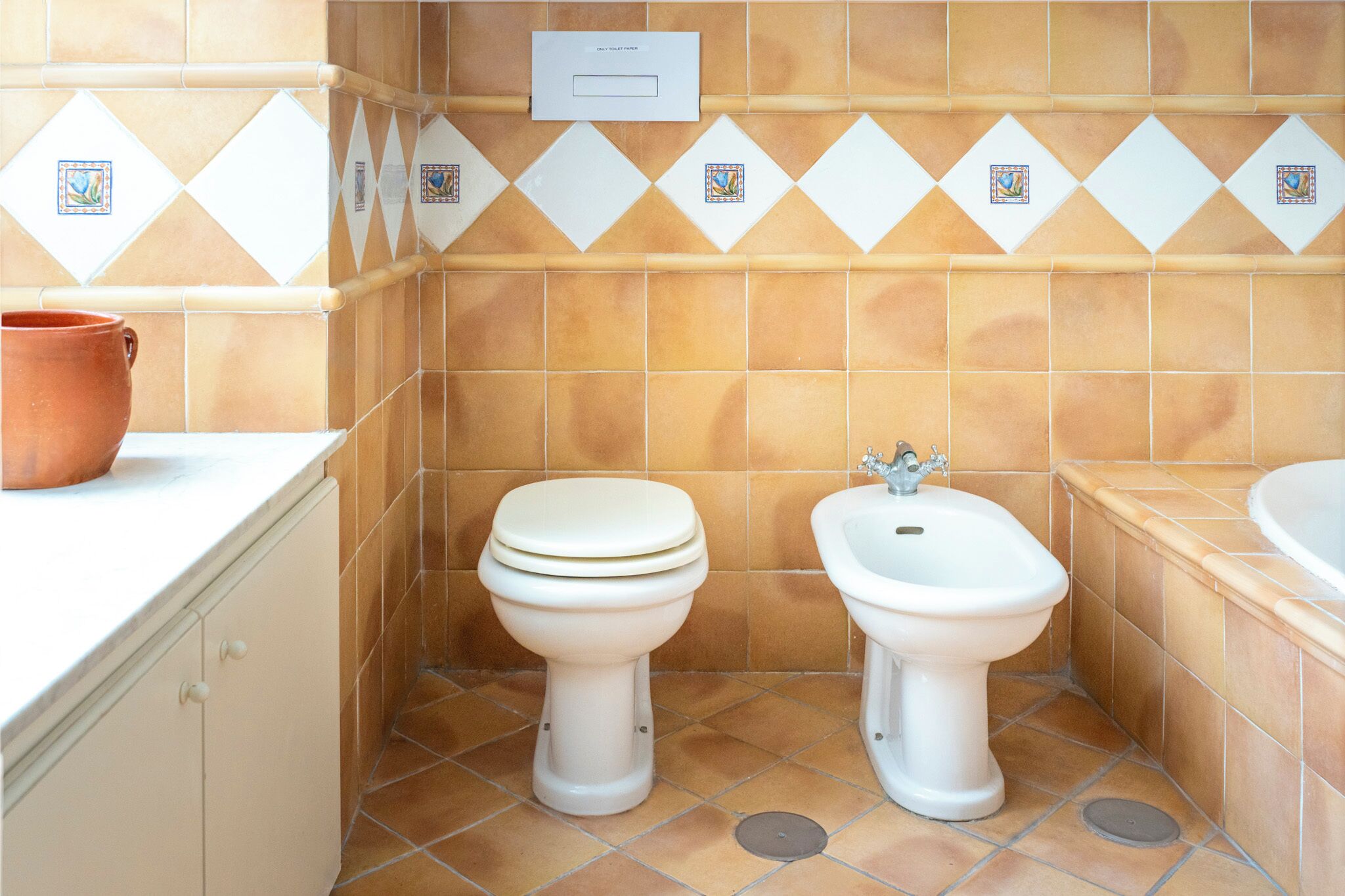 A bathroom with a toilet, bidet, and bathtub.