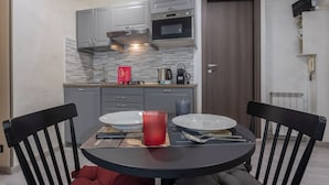 Una cocina moderna con gabinetes grises, una campana extractora de acero inoxidable, un microondas y una cafetera en la encimera.