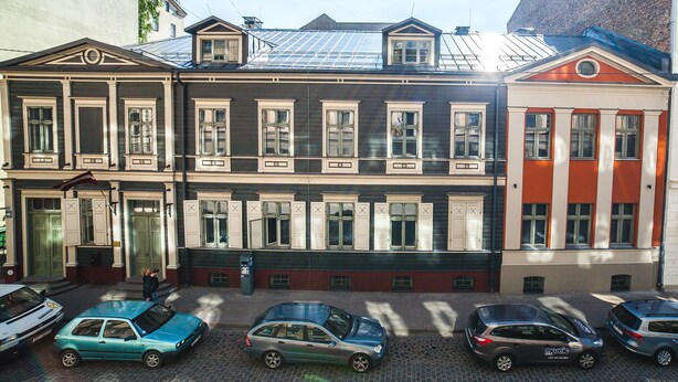 Una hilera de edificios de varios pisos con un estilo arquitectónico uniforme, que cuenta con amplias ventanas y una entrada central.