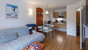 A compact living space with a sofa, dining table, and kitchenette. - Apartment with mountain view - 4 guests (La Mongie)