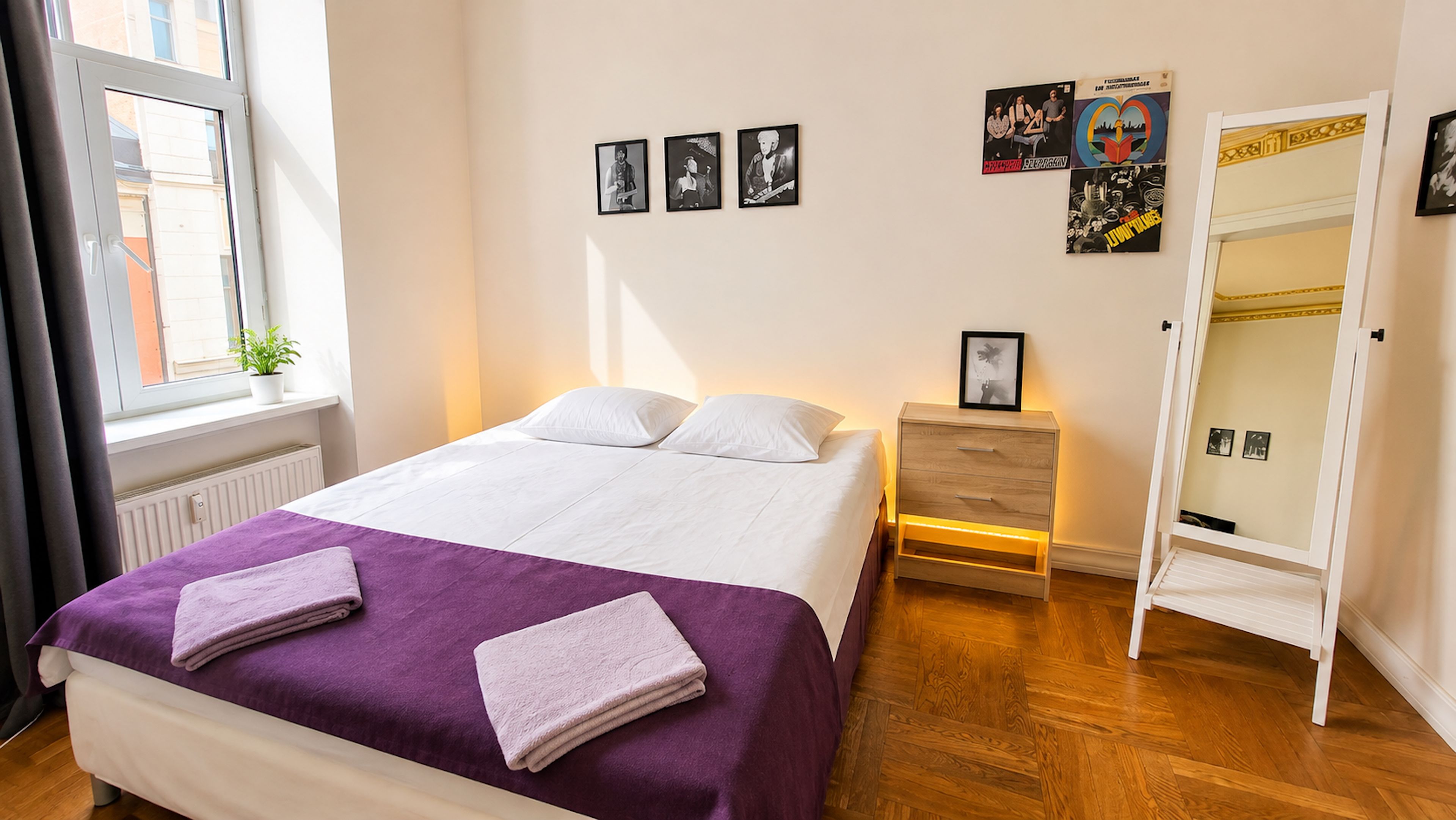 Une chambre à coucher comprenant un lit, une table de chevet, une armoire et des œuvres d’art murales.