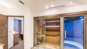 A modern spa room with a glass door leading to a sauna area. - Spacious apartment at the foot of the slopes with SPA access (Méribel)