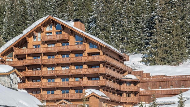 A multi-story wooden lodge with balconies, set in a snowy mountainous area. - Spacious apartment at the foot of the slopes with SPA access (Méribel)