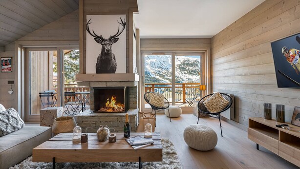 A cozy living room with a fireplace, wooden walls, and a large window overlooking a snowy landscape. - Bright apartment for 6 in Méribel with fireplace (Méribel)