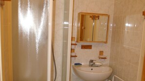 A bathroom with a shower, a sink, and a mirror.
