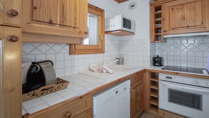 A compact kitchen with wooden cabinets, a microwave, a dishwasher, and a coffee maker.