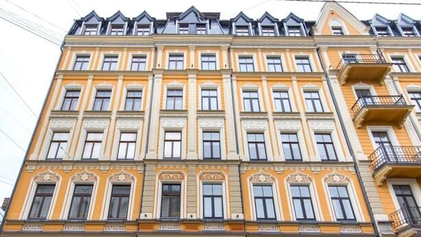 Un edificio de varios pisos con detalles arquitectónicos ornamentados, ventanas grandes y balcones.