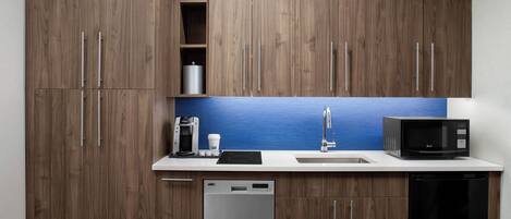 A modern kitchen with wooden cabinets, a stainless steel coffee maker, a microwave, and a dishwasher.