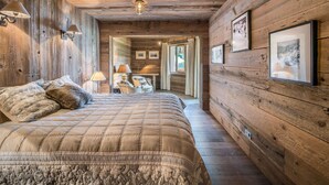 A wooden interior with a bed, a desk, and a framed picture on the wall. - Ski-In Ski-Out Apartment with Spa Access and Mountain Views in Méribel (Méribel)