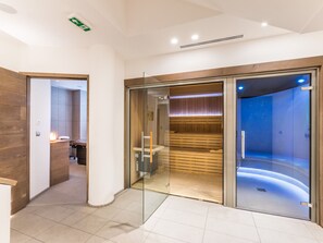 Ein moderner Spa-Bereich mit Glastür zum Sauna-Bereich.
